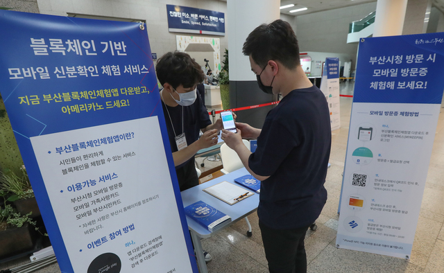 지난해 6월 부산시청 로비에서 시민들이 블록체인 기술을 활용한 모바일 부산시청 방문증 발급 체험을 하고 있는 모습. 부산일보DB