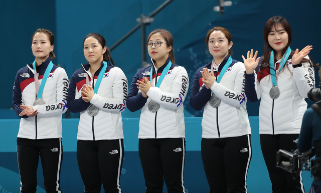 2018 평창올림픽 컬링 여자 결승에서 은메달을 차지한 한국 대표팀이 시상식에서 은메달을 목에 걸고 박수를 치고 있다. 왼쪽부터 김은정, 김경애, 김선영, 김영미, 김초희. 연합뉴스