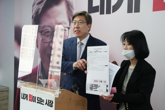 국민의힘 박형준 후보가 15일 선거사무소에서 가족 소유의 엘시티 아파트에 대해 민주당이 제기한 재산등록 누락 의혹을 반박하며 아파트 매매 계약서를 내보이고 있다. 정대현 기자 jhyun@