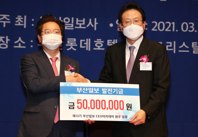 부산일보 CEO아카데미 원장인 김진수 부산일보 사장이 16일 부산롯데호텔에서 열린 제13기 부산일보 CEO아카데미 수료식에서 원우회로부터 발전기금을 전달하고 받고 있다, 강선배 기자 ksun@