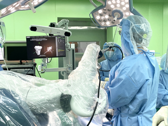 마코 로봇시스템은 무릎 인공관절의 삽입각도, 위치, 절삭범위를 미리 입력한 후 의사가 로봇팔을 직접 들고 수술을 진행한다. 아래 작은 사진은 마코 로봇. 부산부민병원 제공