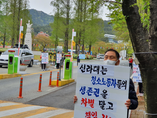 한국노총 부산지역비정규직일반노조 신라대지부 소속 청소노동자들이 12일 오전 부산 사상구 신라대 정문에서 피켓 시위를 하고 있다. 한국노총 제공