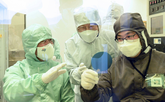 성윤모 산업통상자원부 장관(왼쪽)이 14일 오후 서울 관악구 서울대학교 반도체공동연구소에서 연구원과 메탈이 증착된 반도체 웨이퍼의 표면을 검사하고 있다. 연합뉴스