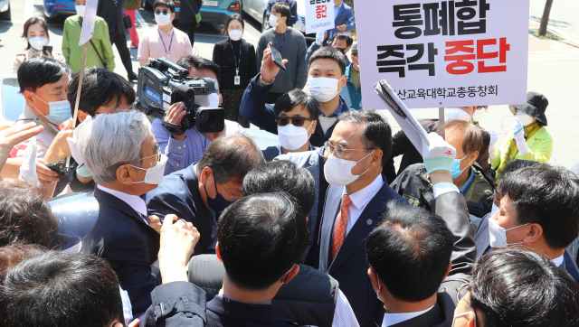 19일 부산교대 본관 앞에서 부산교대 총동창회 회원들이 부산교대와 부산대 통합 양해각서(MOU) 체결을 위해 방문한 차정인 부산대 총장을 막아선 뒤 통합 철회를 요구하고 있다. 이후 두 대학은 서면으로 양해각서를 체결했다. 정종회 기자 jjh@