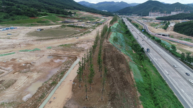 금정산(사진 왼쪽)과 경부고속도로(사진 오른쪽 도로) 사이의 공사 현장에 대한 공사 중지 요청이 내려진 사송신도시 전경. 양산시 제공