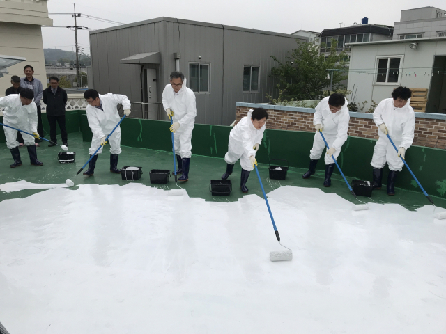 진주시의 한 경로당 옥상에 ‘쿨 루프’ 시공을 하는 모습. 진주시 제공
