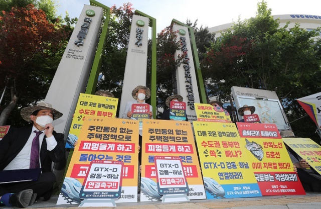 김상호 경기 하남시장, 이정훈 강동구청장 등과 주민 대표들이 12일 정부세종청사 국토교통부 앞에서 수도권광역급행철도(GTX)-D 노선을 김포에서 부천까지만 건설하기로 한 결정에 항의하는 피켓을 들고 있다. 연합뉴스