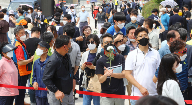 12일 경남 김해시 봉하마을에서 열린 노무현 전 대통령 12주기 추도식에서 추모객들이 묘역 바깥에서 추도식을 지켜보고 있다. 정종회 기자 jjh@busan.com