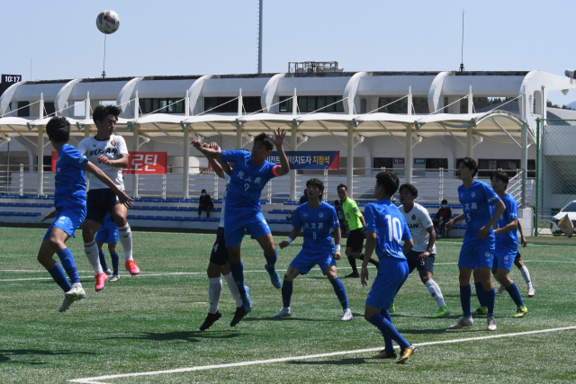 경남 고성군 스포츠파크에서 22일 열린 제58회 청룡기 전국고등학교축구대회 16강 경기에서 맞붙은 부산 FC와 경기 광문고(파란색 유니폼) 선수들이 공중볼을 다투고 있다. 광문고가 부산 FC를 2-1로 꺾고 8강에 진출했다.