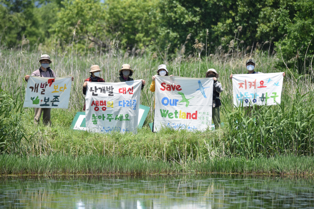 지난 22일 낙동강 하구에서 습지와새들의친구 회원들이 생물 다양성의 날을 맞아 대저대교 건설 철회를 요구했다. 왼쪽 사진은 삼락생태공원에서 발견된 ‘대모잠자리’. 습지와새들의친구 제공