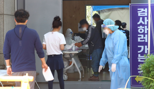 부산의 코로나19 신규 확진자가 21명 발생한 지난 25일 오후 부산 금정구보건소 선별진료소에서 시민들이 코로나19 진단 검사를 받고 있다. 부산일보 DB