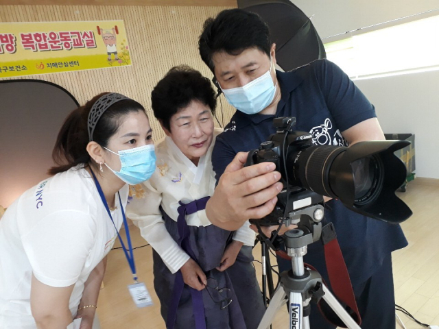 부산가톨릭대의 ‘웰다잉’ 교육 중 어르신이 영정 사진을 촬영한 뒤 카메라를 보며 사진을 확인하고 있다. 부산가톨릭대 제공