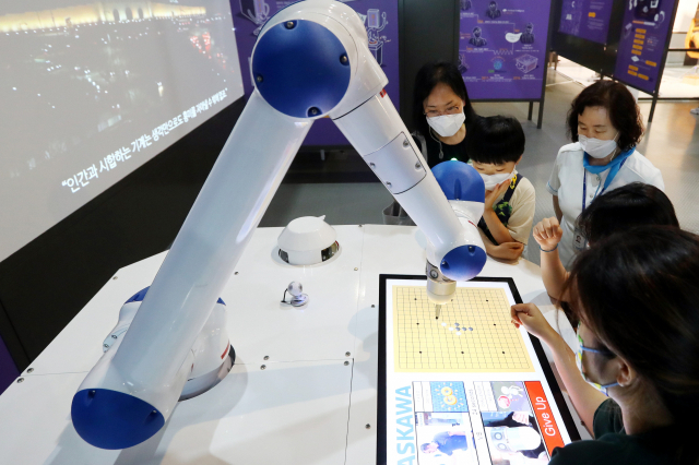 지난 22일 부산 기장군 국립부산과학관 김진재홀에서 개막한 ‘헬로 로봇’ 전시에서 관람객들이 인공지능 오목 로봇과 오목 대결을 벌이고 있다. 정종회 기자 jjh@
