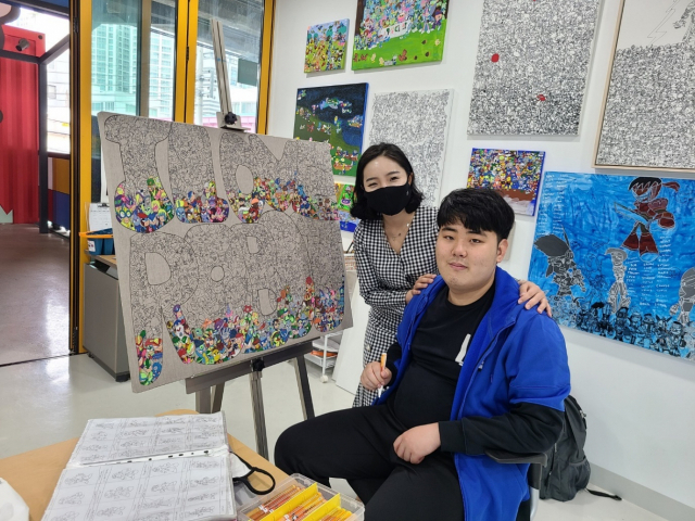 브이드림 김민지 대표와 발달장애예술인 황성제 작가가 노트 굿즈 제작과 관련한 계약을 체결하고 기념사진을 찍고 있다. 브이드림 제공