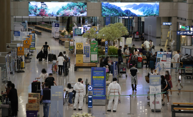 27일 인천국제공항 입국장에서 외국인 등이 대기하고 있다. 전 세계적으로 신종 코로나바이러스 감염증 '델타형' 변이가 확산하는 가운데 최근 국내 해외유입 확진자 수가 눈에 띄게 늘어 당국이 촉각을 세우고 있다. 연합뉴스