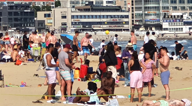 지난 5월 29일 오후 부산 해운대해수욕장에 주한미군과 지인들로 보이는 외국인들이 마스크를 착용하지 않고 무리지어 있다. 부산일보DB