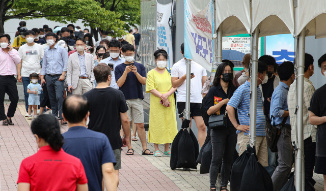 6일 오전 서울 마포구 서강대역 환승공영주차장 인근에 마련된 코로나19 임시선별검사소에 진단 검사를 받으려는 시민들이 줄지어 서 있다. 연합뉴스