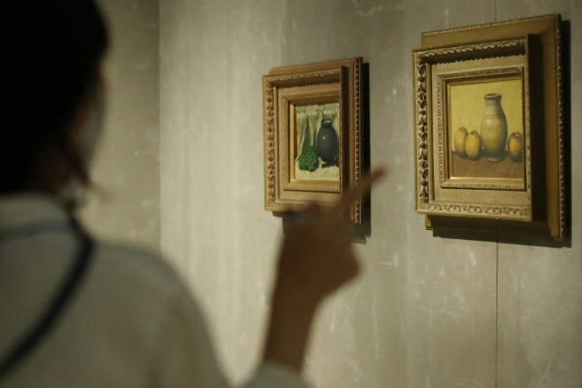 6일 오후 서울 중구 국립현대미술관 덕수궁관에서 열린 'DNA: 한국미술 어제와 오늘' 전 언론공개회에서 참석자가 고 이건희 삼성그룹 회장 컬렉션 도상봉의 '포도 항아리가 있는 정물'과 '정물A'를 살펴보고 있다. 연합뉴스