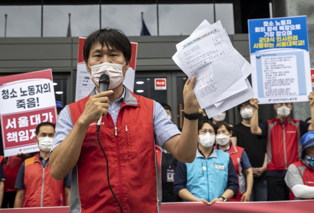 7일 서울대학교 행정관 앞에서 열린‘서울대학교 청소 노동자 조합원 사망 관련 서울대학교 오세정 총장 규탄 기자회견’에서 민주노총 조합원이 청소 노동자가 본 시험지를 들어 보이고 있다. 연합뉴스