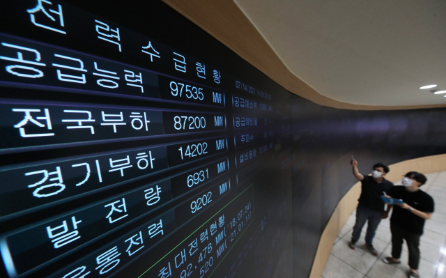전국에 폭염특보가 내려지며 전기 사용량이 늘어나고 있는 지난 14일 오후 경기도 수원시 한국전력공사 경기지역본부 전력관리처 계통운영센터에서 관계자들이 전력수급 상황을 점검하고 있다. [연합뉴스]