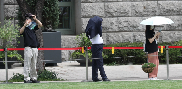 같은 날 서울광장 임시선별진료소에서 시민들이 햇빛을 피하며 검사를 기다리고 있다. [연합뉴스]
