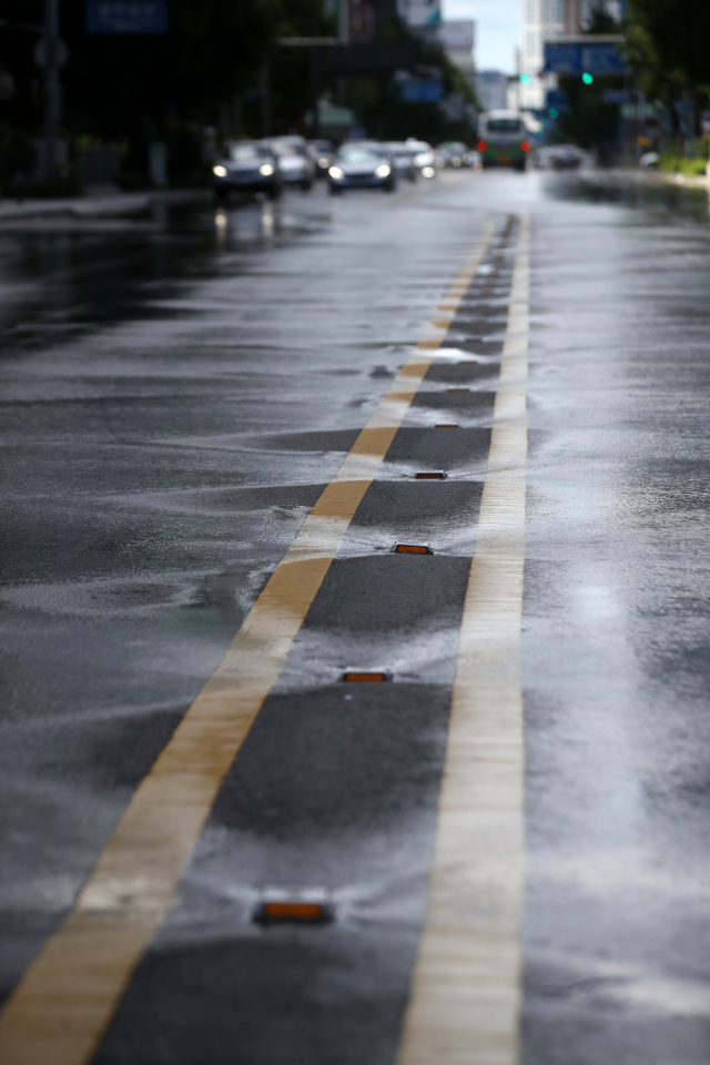 전국적으로 폭염이 이어진 지난 15일 오후 광주 금남로 중앙차선에 설치된 '클린로드'에서 뿜어져 나온 물줄기가 도로를 적시고 있다. 금남로의 클린로드는 기온이 30도가 넘으면 오전 10시, 오후 2시, 4시에 가동해 아스팔트의 열기를 식힌다. [연합뉴스]