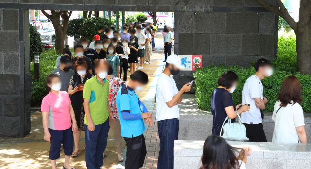 부산의 코로나19 신규 확진자가 97명 발생해 역대 최다를 기록한 20일 오후 동래구보건소 선별진료소에서 많은 시민들이 검진을 받기 위해 줄을 서 있다. 부산시는 21일 0시부터 12일간 사회적 거리두기를 3단계로 강화하기로 결정했다. 정종회 기자 jjh@