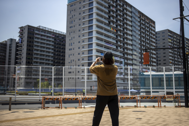 한 시민이 20일 도쿄 하루미 지역 올림픽선수촌 한국 숙소동 주변에서 사진을 찍고 있다. 연합뉴스