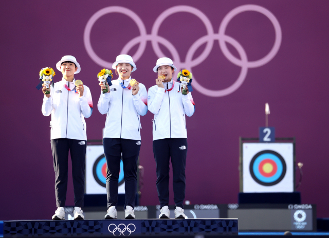 25일 일본 유메노시마 공원 양궁장에서 열린 도쿄올림픽 여자 양궁 단체 결승전 러시아올림픽위원회(ROC)와의 경기에서 이겨 금메달을 딴 여자 양궁 국가대표 안산(왼쪽), 장민희(가운데), 강채영이 시상대에서 금메달을 들어 보이고 있다. 연합뉴스