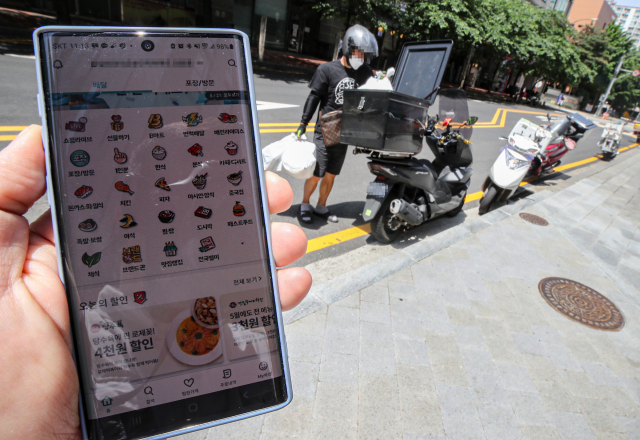 올해 2분기 온라인쇼핑 거래액이 전년 대비 25.1% 늘어 역대 최고 증가율을 기록했다. 특히 배달앱을 통한 음식 주문을 포함한 ‘음식서비스’ 부문은 58.7%나 늘었다. 유명 배달업체 앱과 배달 음식을 싣는 배달업체 관계자. 연합뉴스