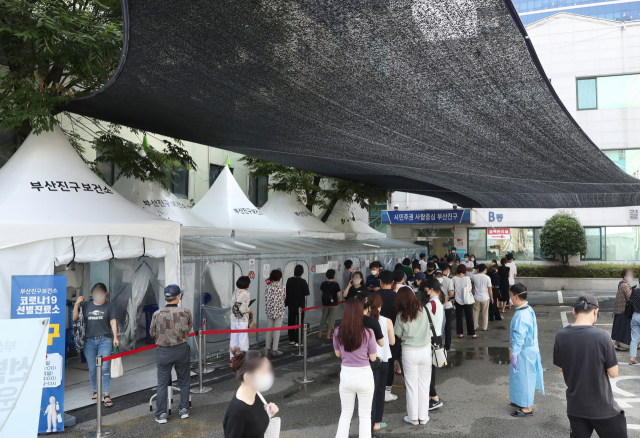 계속되는 폭염 속에 4일 오후 부산진구보건소 선별진료소에서 시민들이 그늘막 아래 길게 줄을 선 채 검사 차례를 기다리고 있다. 정대현 기자 jhyun@