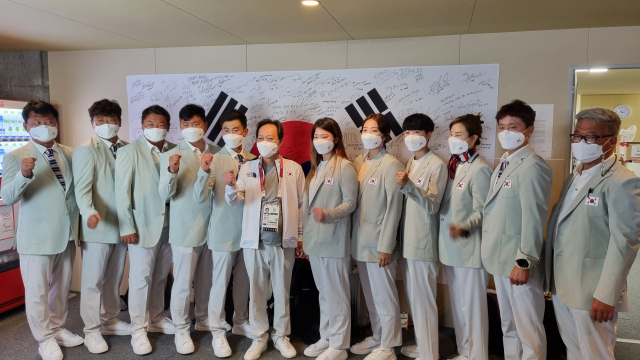 장인화 도쿄올림픽 대한민국선수단 단장이 대회를 마치고 중도 귀국하는 선수들과 기념촬영을 하고 있다. 대한체육회 제공