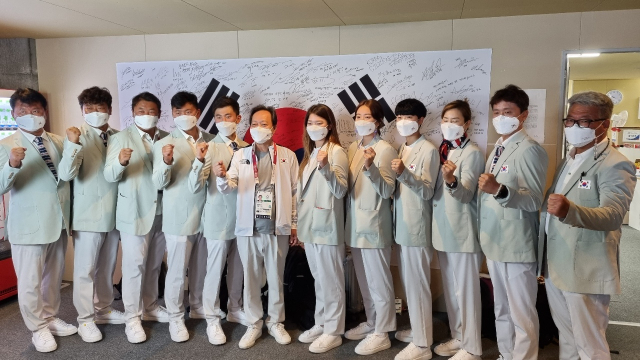 장인화 도쿄올림픽 대한민국선수단 단장이 대회를 마치고 중도 귀국하는 선수들과 기념촬영을 하고 있다. 대한체육회 제공