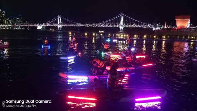 보드 위에서 노를 젓는 SUP(Stand Up Paddleboard·스탠드 업 패들보드)는 남녀노소 누구나 즐길 수 있는 해양스포츠다. 부산 광안리 해변은 파도가 잔잔해 전국에서도 손꼽히는 ‘SUP 명소’로 각광받고 있다. 수영구청은 ‘광안리 SUPrise’ 사업을 통해 요가와 야간 SUP 체험 등 이색 프로그램을 상시 운영 중이다. 수영구청 제공