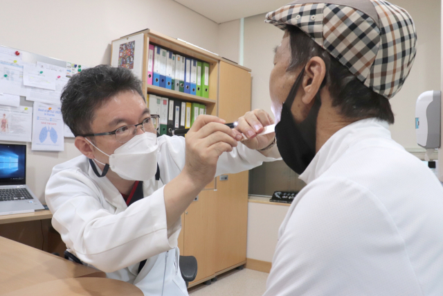 좋은강안병원 주영돈 진료부원장이 구강내 편도선에 악성 림프종이 침범했는지를 확인하고 있다. 좋은강안병원 제공