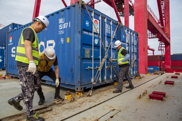 최근 항만 적체로 하역과 화물고정(라싱) 등 부대작업을 마치고 선박이 출항하기까지 시간이 크게 지연되고 있다. 라싱 작업 모습. 부산항만공사 제공