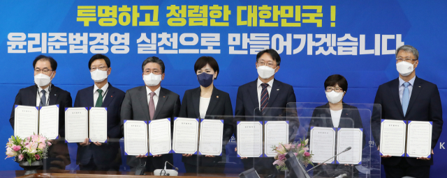 전현희 권익위원장과 6개 공기업 사장들이 12일 오후 세종시 정부세종청사에서 열린 '윤리준법경영 인증 시범 운영기관 업무 협약식'에서 협약서에 서명한 뒤 기념촬영을 하고 있다. 왼쪽부터 이승 한국가스공사 부사장, 황창화 한국지역난방공사 사장, 정승일 한국전력공사 사장, 전현희 위원장, 김현준 한국토지주택공사 사장, 김진숙 한국도로공사 사장, 박재현 한국수자원공사 사장. 연합뉴스