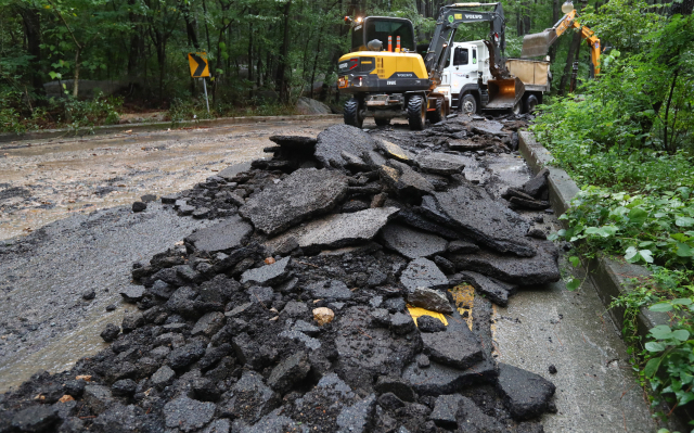 제14호 태풍 찬투가 한반도로 향하고 있는 가운데, 지난 8월 제12호 태풍 ‘오마이스’로 파손된 부산 금정구 산성로의 아스팔트 도로 복구 장면. 정종회 기자 jjh@