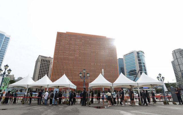 추석 연휴가 끝나고 코로나19 신규 확진자가 연일 폭증하면서 결국 3천명을 넘어선 가운데 25일 오전 서울역 광장에 마련된 중구임시선별검사소에서 시민들이 검사를 받기 위해 기다리고 있다. 연합뉴스