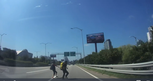 지난 12일 중년 커플이 올림픽대로를 무단횡단하고 있는 모습. 해당 운전자는 급정거로 사고를 모면했다며 가슴을 쓸어내렸다. '보배드림' 캡처