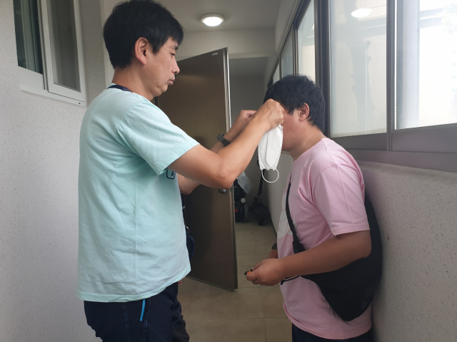 외출에 앞서 정재욱 씨가 김한민 씨에게 마스크를 씌워 주고 있다. 함세상장애인자립센터 제공