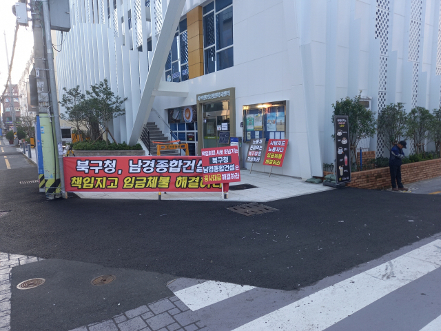부산 북구 덕천2동 행정복지센터 앞에 하도급 업체의 임금 체불을 호소하는 현수막이 붙어있다.