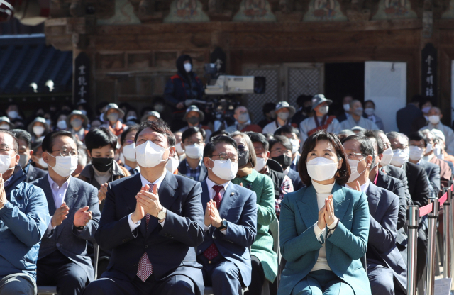 18일 경남 양산시 통도사에서 열린 삼보사찰 천리순례 회향식에 국민의힘 윤석열(앞줄 중앙) 대권 예비후보와 더불어민주당 이재명 대선 후보 부인 김혜경(앞줄 오른쪽) 씨가 나란히 앉아 손뼉 치고 있다. 연합뉴스