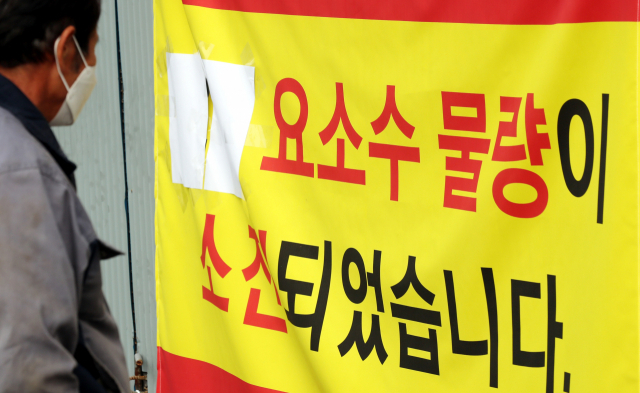 중국발 요소수 품귀 현상이 빚어진 4일 오전 경기도 부천시 한 요소수 제조업체 앞에서 한 트럭 운전사가 '요소수 판매가 무기한 중단됨을 알려드립니다'라고 적힌 안내문을 본 뒤 발걸음을 떼지 못하고 있다. 이 업체는 요소수 제조 원료가 바닥나 요소수를 더는 판매할 수 없다고 설명했다. 연합뉴스