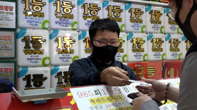권 사장님은 당첨을 바라는 기운을 한가득 넣어 로또를 발권한다.