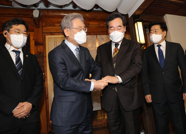 이재명 대선후보와 이낙연 전 대표가 지난달 24일 오후 서울 종로구 안국동 한 찻집에서 회동하며 손을 잡는 모습. 연합뉴스