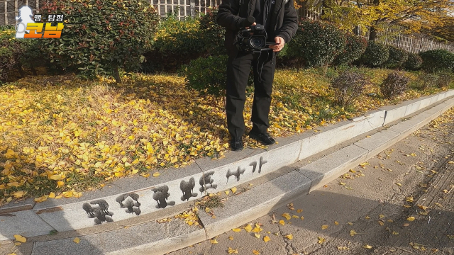 누군가 급하게 휘갈겨 쓴 '몸속 로보트 나가'. 도로 옆 연석에 쓰여져 있었다.