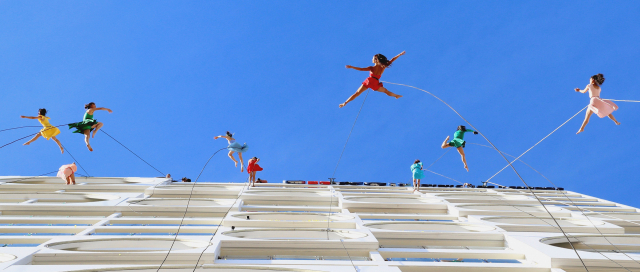 푸른 하늘을 배경으로 부산 수영구 광안리해변의 한 고층 건물에서 로프에 의지한 채 댄스 공연이 펼쳐지고 있다. 부산일보DB