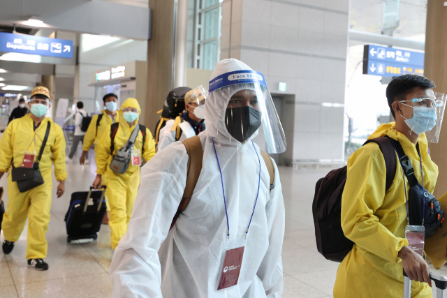 29일 오전 방호복을 입은 해외 입국자들이 인천국제공항을 통해 입국하고 있다. 방역 당국은 새로운 코로나19 변이 바이러스인 '오미크론'의 국내 유입 차단을 위해 남아프리카 8개국에서 오는 외국인을 입국금지 조처했으며, 향후 대상 국가를 확대하는 방안을 검토할 방침이다. 연합뉴스