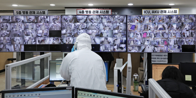 코로나19 위중증 환자 수가 774명으로 최다를 기록한 7일 코로나19 거점 전담병원인 경기도 평택 박애병원 상황실에서 방호복을 입은 의료진이 병동 관제 시스템을 통해 병상 상황을 확인하고 있다. 정부는 위중증 환자 병상 확보를 위해 코로나19 거점 전담병원 2곳을 추가 지정했다. 연합뉴스
